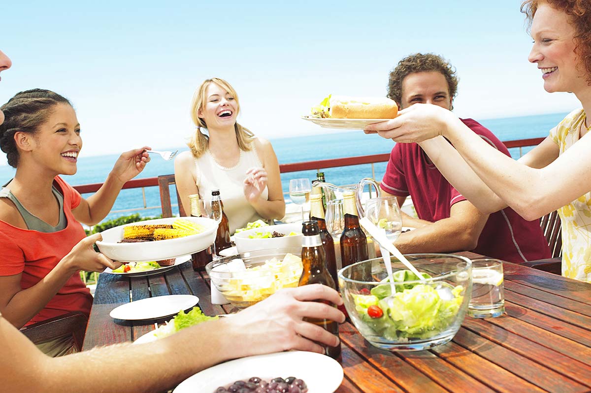 Groupe d'amis déjeunant en terrasse en bord de mer en Vendée